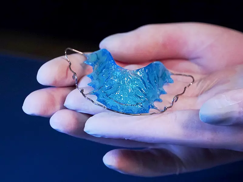 Dispositivo odontológico em mãos.